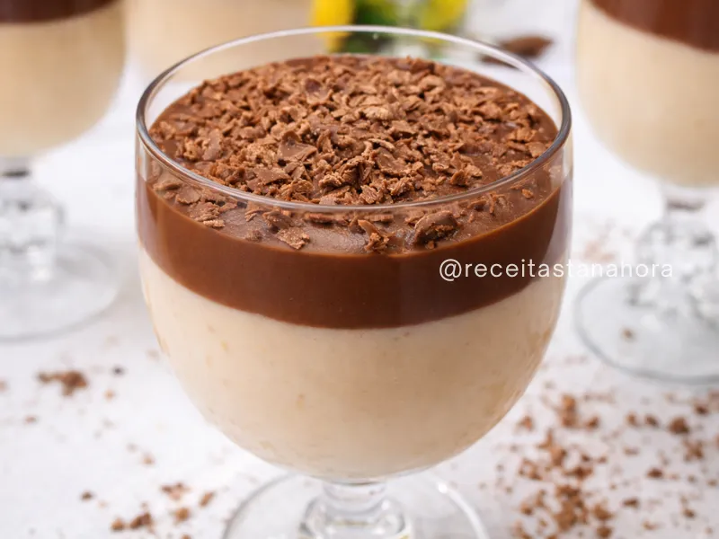 mousse cremoso de maracujá com cobertura de chocolate e raspas por cima servido em taça de vidro